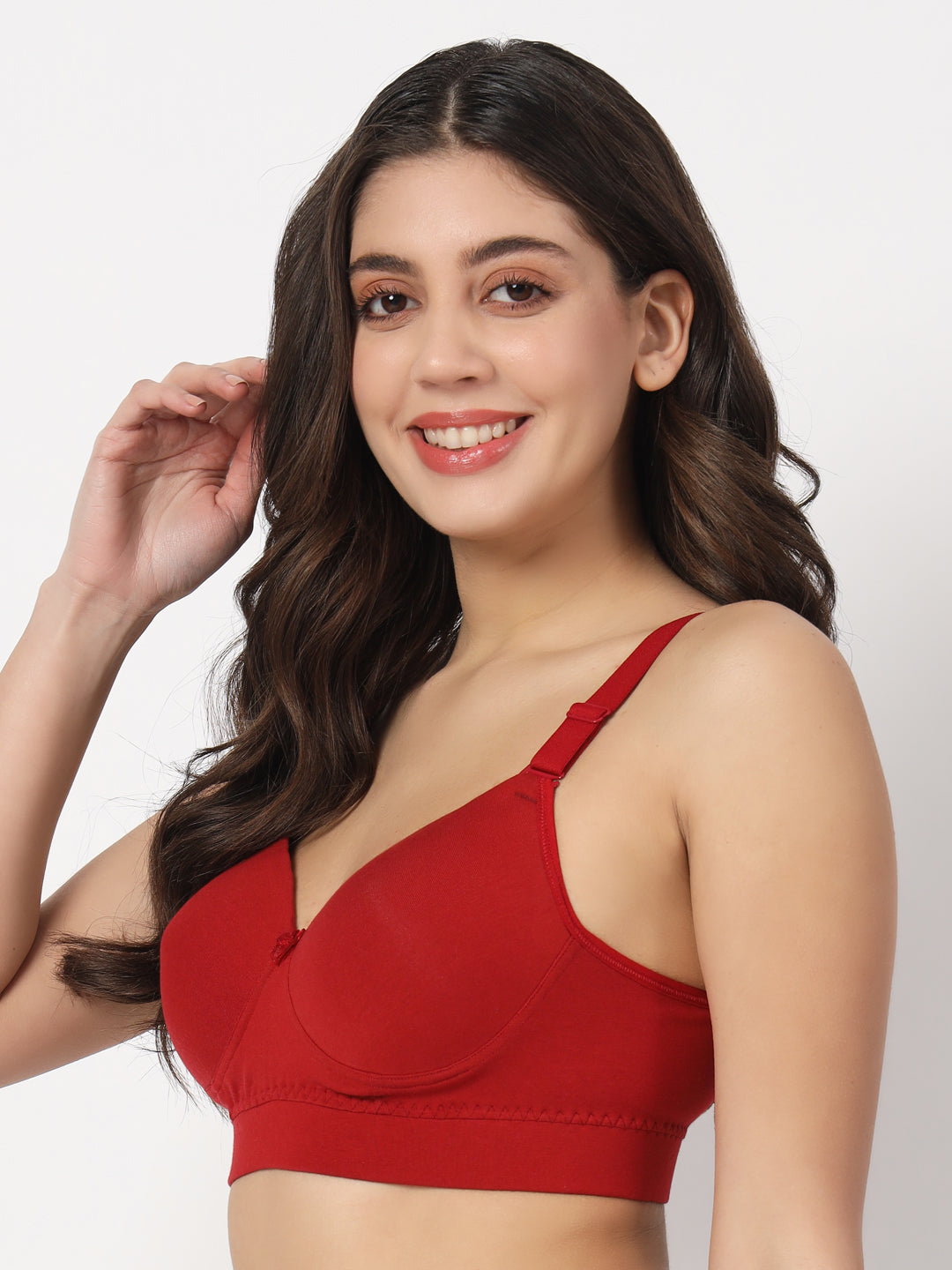 A woman is wearing a red padded bra with a V-neckline and sleeveless design.