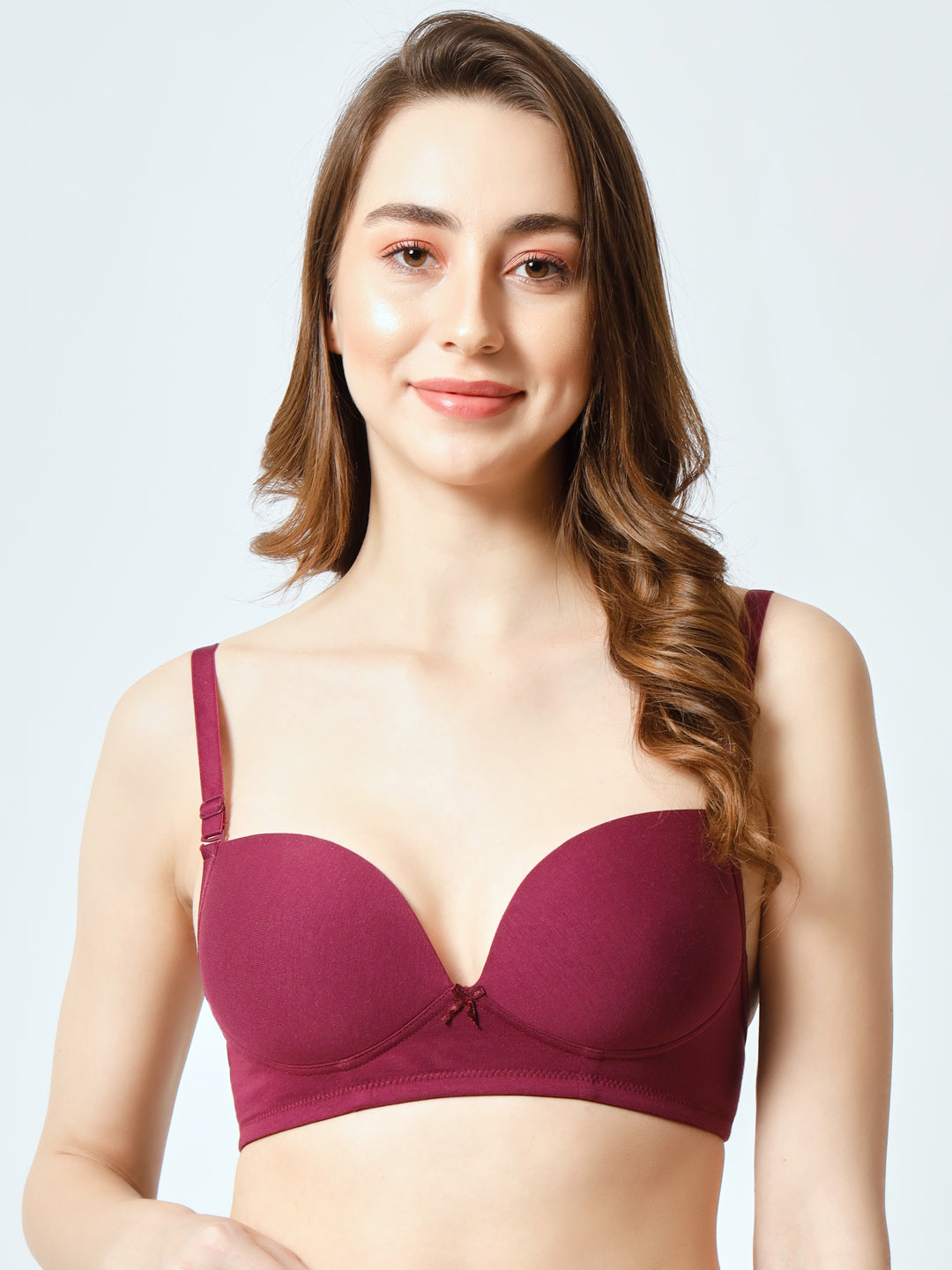 A woman wearing a red padded non-wired t-shirt bra with detachable straps and a three-pin back closure.